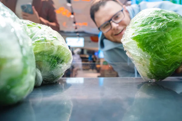 微笑的人从商店的货架上寻找蔬菜从顾客那里购买商品 — 图库照片