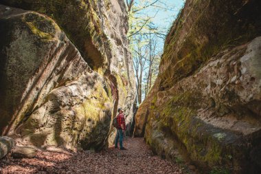 Sırt çantalı bir adam Ukrayna 'daki kanyon güvercini kayalarında yürüyor.