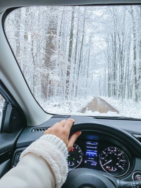 Dışarısı karlı, kadın elleri direksiyonda.