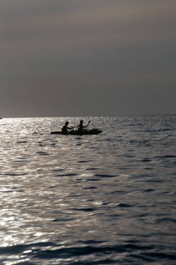 Gün batımında denizdeki kano silueti