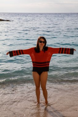 Deniz kıyısındaki portrede gülümseyen güzel bir kadın.