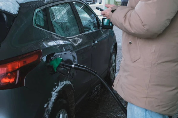 man fills up car and pays for gas through application on his phone