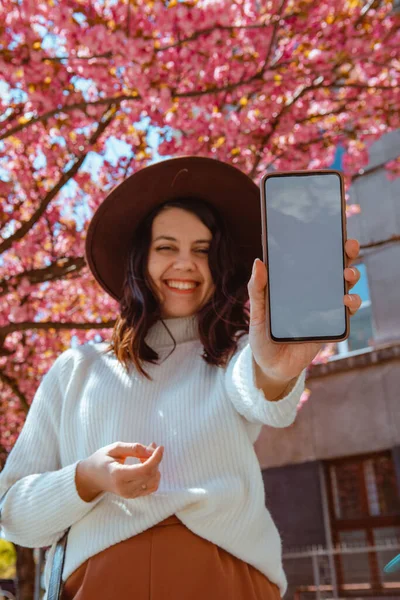 Uśmiechnięta Piękna Kobieta Trzyma Telefon Białym Ekranem Przestrzeń Kwitnące Sakura — Zdjęcie stockowe