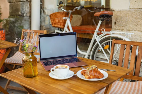 노트북 크로와 커피를 마시는 카페의 테라스 — 스톡 사진