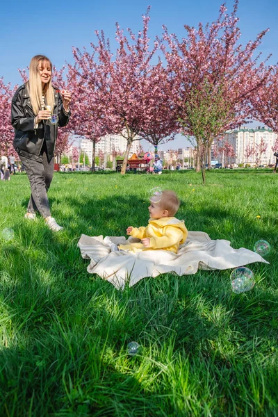 Радісна Мати Син Грають Бульбашками Під Вишневими Квітами — стокове фото