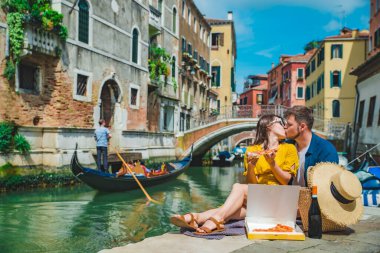 Venedik Kanalı manzaralı ve pizza yiyen çift.