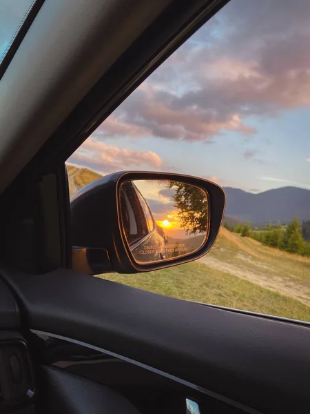 stock image sunset in the Carpathians reflected in the mirror of the car