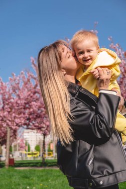Anne mutlu gülümseyen çocuğunu öper.