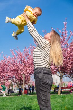 Sevgi dolu anne bebeğini yükseğe kaldırıyor..