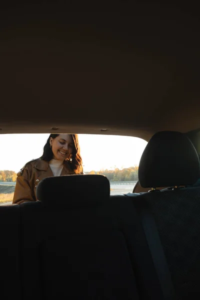 Het Smiley Vrouw Neemt Dingen Uit Kofferbak Van Auto Bekeken — Stockfoto
