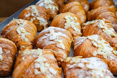 Badem gevreğiyle pişmiş kruvasan serpiştirin.