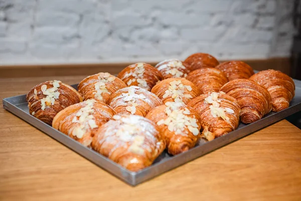 Sprinkle finished croissants on baking sheet with almond flakes