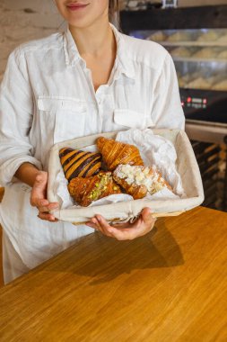 Kasadaki satıcı sepette kruvasan servis ediyor.
