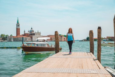 Turist kadın San Giorgio Maggiore Venedik 'e bakıyor.