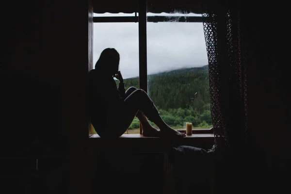 소녀는 창턱에 있었다 창밖에 산들의 모습이 보인다 — 스톡 사진