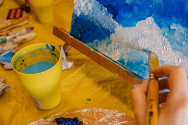 tuval sınıfında fırça boyası tutan kadın.