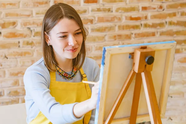 Tuvalde fırça boyası olan bir kadın.
