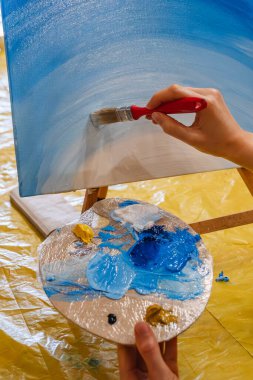 tuval sınıfında fırça boyası tutan kadın.