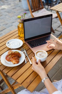 Kafede dizüstü bilgisayarda kadınlar yazıyor..