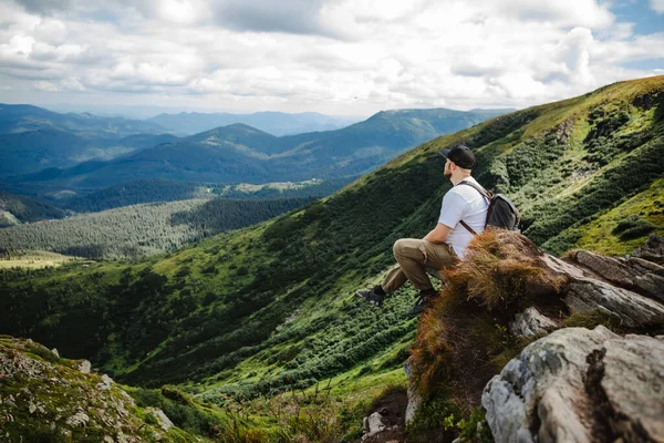 岩の上に座っている山の上の男 — ストック写真