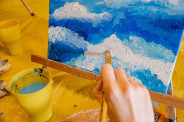 tuval sınıfında fırça boyası tutan kadın.