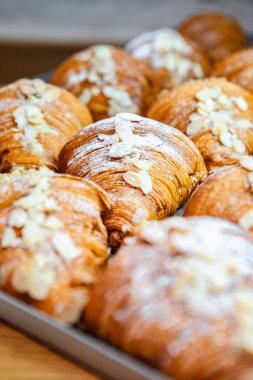 Badem gevreği ve pudra şekerli kruvasanları fırına serp.