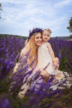 Gülümseyen anne, lavanta tarlasında kızına sarılıyor. Lavanta tarlasında aile pikniği