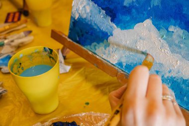 tuval sınıfında fırça boyası tutan kadın.