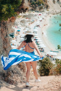 Yunan bayrağıyla Lefkada adasına koşan mutlu, güzel bir kadın.