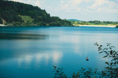 Mutlu adam gölün ortasındaki fotokopi odasında güneşlenerek yatar.