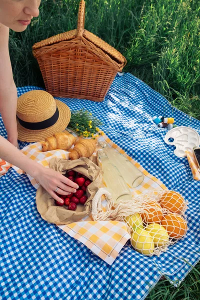 Young Woman Picks Strawberry Picnic Nature While Sitting Blue Blanket — Stock Photo, Image