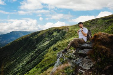 Dağın tepesinde Kaya 'da oturan adam