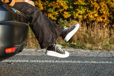 Bir otomobilin bagajında, dışarı fırlayan kadın bacakları var. Uzun bir yolculuktan sonra dinlen.