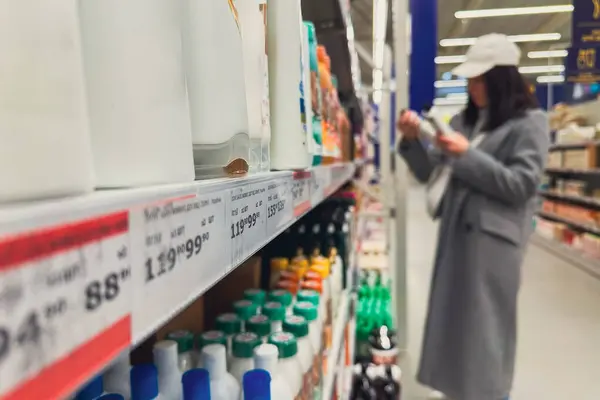woman in groceries store choosing shampoo copy space