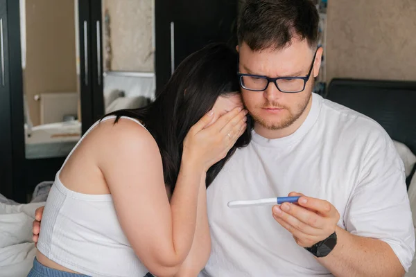 stock image worried couple looking at positive pregnancy test unwanted