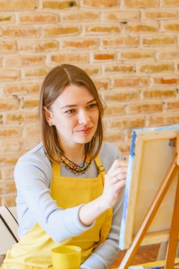 Tuvalde fırça boyası olan bir kadın.