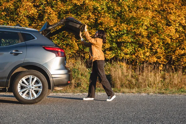 Γυναίκα Κλείνει Πορτ Μπαγκάζ Του Αυτοκινήτου Της Πίσω Από Φθινόπωρο — Φωτογραφία Αρχείου