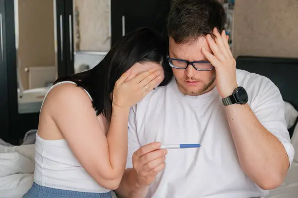 stock image worried couple looking at positive pregnancy test unwanted