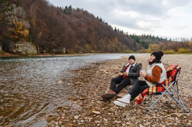 Mutlu çift River Beach sonbahar sezonunda piknik yapıyor.