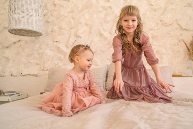 Pembe portredeki iki beyaz kız kardeş.