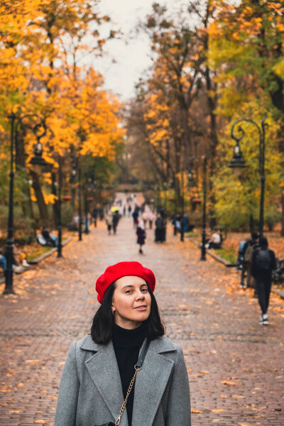 beautiful woman in autumn outfit at city public park copy space