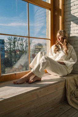 Pencerenin yanındaki güzel kadın parlak güneş fotokopi alanı ile vurgulanmış.
