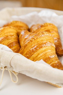 Dokuma sepetinde taze pişmiş kruvasan.