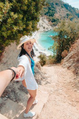 follow me concept woman pulling man to the sea beach Lefkada island Greece vacation