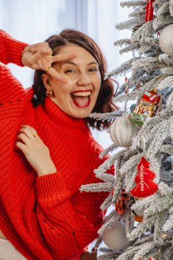 Evde Noel ağacı süsleyen güzel bir kadın.