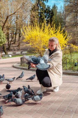Kamu parkında güvercinleri besleyen kadın