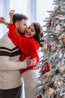 Evdeki Noel ağacını süsleyen çift.