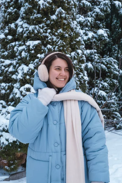 portrait of happy beautiful woman outside at cold winter day snowy outfit