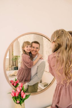 Baba ve kızı aynada yansıyor.