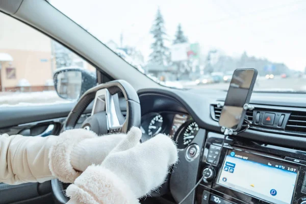 woman hands in winter gloves on steering wheel copy space